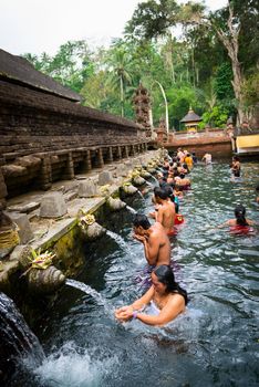 TIRTA EMPUL, INDONESIA - SEP 21: Bali prayers take a bath  in the sacred holy spring water on Sep 21, 2012 in Tirta Empul, Bali, Indonesia. It is famous place for purification of Bali people