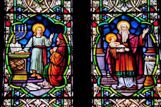 Baby Jesus with Joseph and Young Jesus Teaching Stained Glass in National Shrine of Saint Francis of Assisi San Francisco California.  Church has relics of St Francis.  This church was founded in 1849 and rededicated in 1919 after church was destroyed in 1905 earthquake.