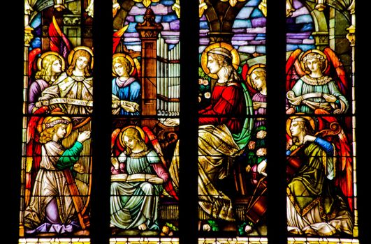 Angels Playing Music Stained Glass in National Shrine of Saint Francis of Assisi San Francisco California.  Church has relics of St Francis.  This church was founded in 1849 and rededicated in 1919 after church was destroyed in 1905 earthquake.