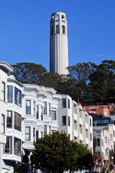 Coit Tower Row Houses San Francisco California on Telegraph Hill.  Airplane in the background. Coit Tower was built in 1933.  Little Hitchcock Coit left one third of her estate to the City to build the Tower.