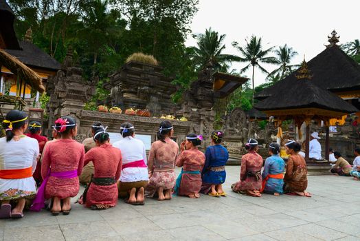 TAMPAK SIRING, BALI, INDONESIA - SEP 21: People praying at holy spring water temple Puru Tirtha Empul during the religious ceremony on Sep 21, 2012 in Tampak Siring, Bali, Indonesia