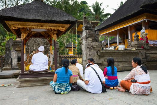 TAMPAK SIRING, BALI, INDONESIA - SEP 21: People praying at holy spring water temple Puru Tirtha Empul during the religious ceremony on Sep 21, 2012 in Tampak Siring, Bali, Indonesia