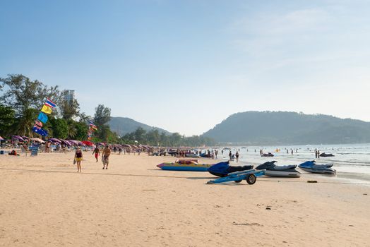 PHUKET, THAILAND - Jan 28: Patong beach with tourists and water scooters on Jan 28, 2013 in Phuket, Thailand. Phuket is a famous winter destination for thousands of tourists. 