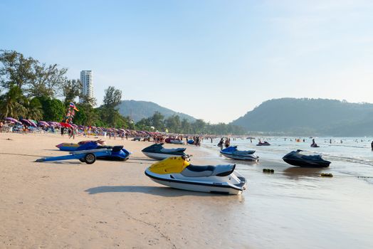 PHUKET, THAILAND - Jan 28: Patong beach with tourists and water scooters on Jan 28, 2013 in Phuket, Thailand. Phuket is a famous winter destination for thousands of tourists. 