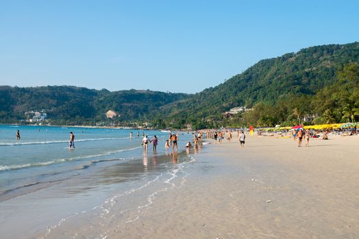 PHUKET, THAILAND - Jan 28: Patong beach with tourists on Jan 28, 2013 in Phuket, Thailand. Phuket is a famous winter destination for thousands of tourists. 