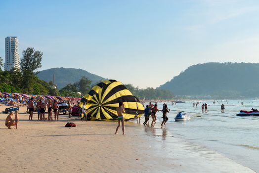 PHUKET, THAILAND - Jan 28: Crowded Patong beach with tourists on Jan 28, 2013 in Phuket, Thailand. Phuket is a famous winter destination for thousands of tourists. 