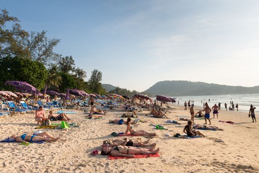 PHUKET, THAILAND - Jan 28: Crowded Patong beach with tourists on Jan 28, 2013 in Phuket, Thailand. Phuket is a famous winter destination for thousands of tourists. 