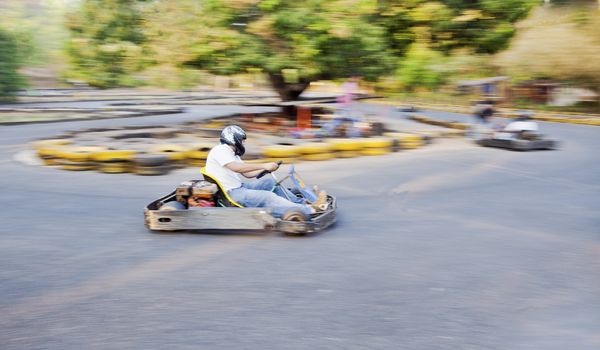 Horizontal generic grab at a public go kart track in Goa during a race, position of shot from the safety barriers at a U bend.