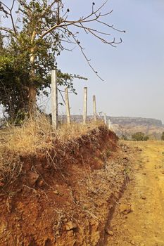 In the background are the Sahyadhri mountains in Maharashtra India, families have lived and worked as they have done for centuries, without electrical power or running water. Recycling, living of the land harvest and eco system where ever possible and almost everything is biodegradable. Now the developers are coming, the pillars are up, fence will follow