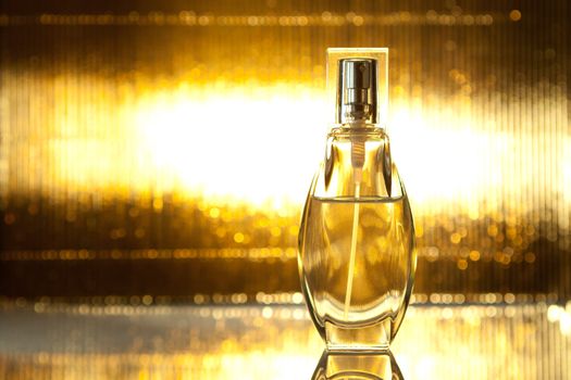 Bottle of perfume on shiny gold background