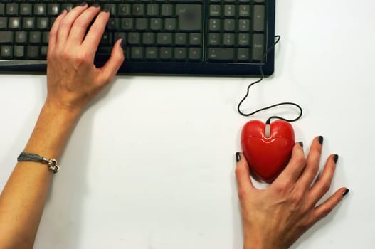 A lady holds a heart shaped mouse for on-line dating