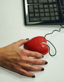 A lady holds a heart shaped mouse for on-line dating