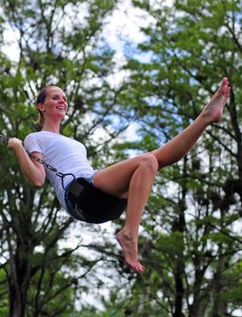 Young woman swinging, smiling and enjoying life