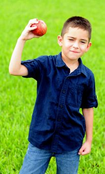 Young boy holding up an apple for a healthy food choice