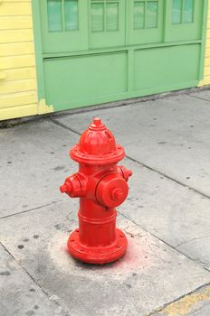 red fire hydrant near yellow and green building