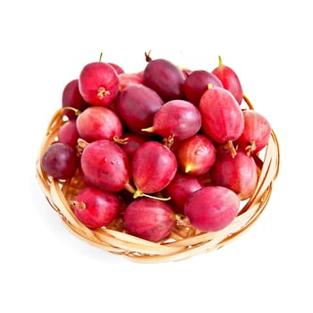 Berries of red gooseberries on a straw wicker plate isolated on a white background