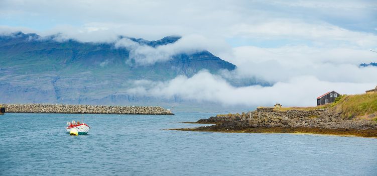 Rural beautiful summer landscape - fjord, boat, mountains. Iceland. Panorama.