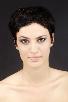 beautiful girl with short black hair, against black background