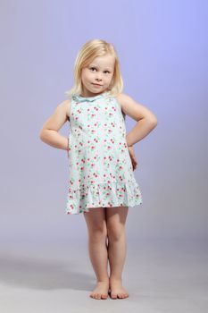 cute little blond girl posing against blue background