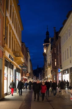 Heidelberg, Germany - February 2, 2013: Tourists walking through the centre of Heidelberg, Germany with its beautiful medieval houses in the evening of February 2, 2013. Heidelberg is a well-known tourist attraction due to its old history and beautiful location at the Neckar river.