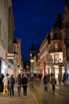 Heidelberg, Germany - February 2, 2013: Tourists walking through the centre of Heidelberg, Germany with its beautiful medieval houses in the evening of February 2, 2013. Heidelberg is a well-known tourist attraction due to its old history and beautiful location at the Neckar river.