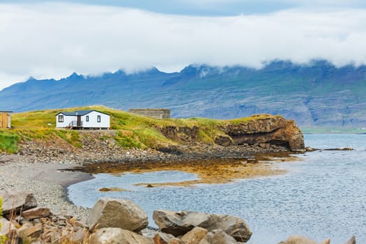 Rural beautiful summer landscape - fjord, house, mountains. Iceland.