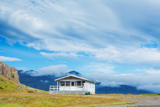 Beautiful house in Iceland. Mountains in background.