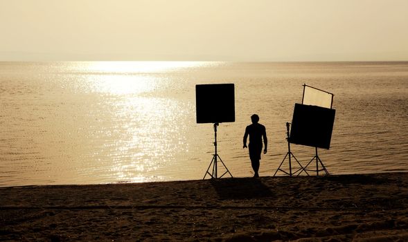 film crew setting up scene on a beach