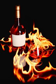 wine brandy bottle and a glass with fire