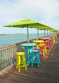 Multi-colored chairs on deck overlooking tropical ocean