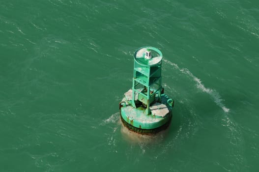 green buoy in ocean water