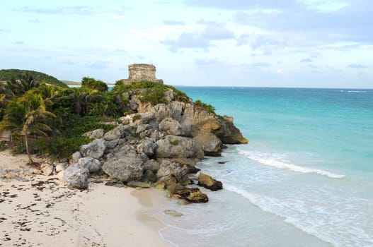 Beautiful beach and ocean with ancient mayan ruin on a cliff