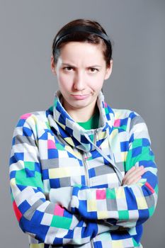 girl with expression on her face, against grey background