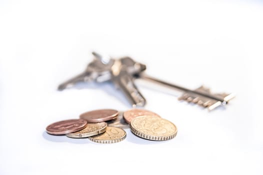 Home keys and coins concept, isolated in white