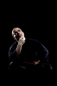 portrait of a kendo fighter with bokken, against black backgroung