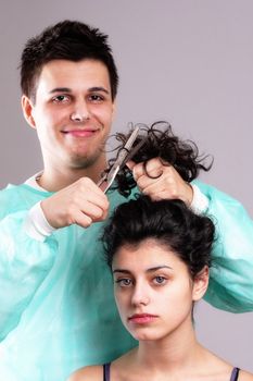 portrait of a barber cutting female hair