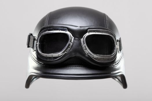 old-style us army motorcycle helmet with goggles, on gray background