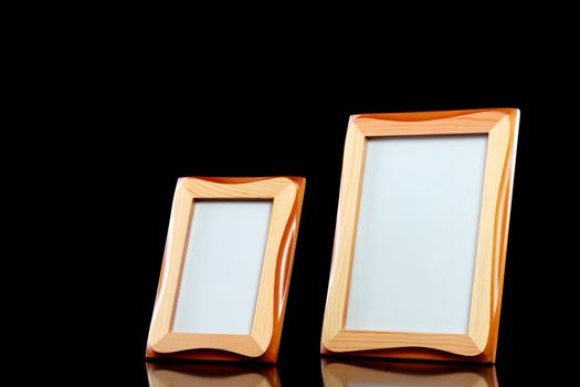 two wooden picture frames against black background