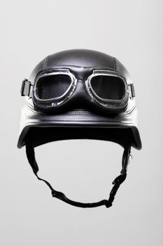 old-style us army motorcycle helmet with goggles, on gray background