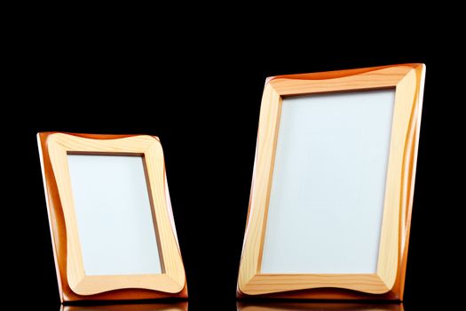 two wooden picture frames against black background