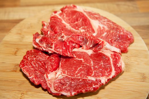 Raw beef on wooden cutting board in closeup