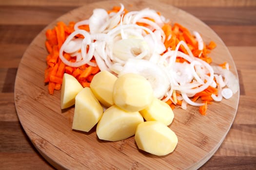 Ingredients for Dutch hutspot stew on wooden cutting board in closeup 
