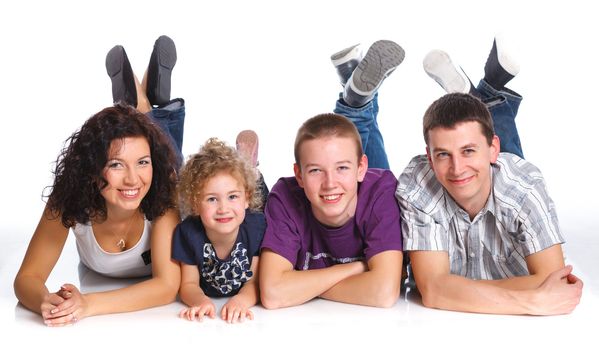 Beautiful middle aged couple lying with cute kids and smiling over white background