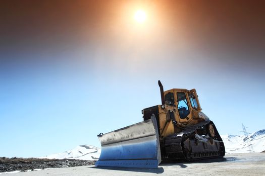 snow cleaning bulldozer on a mountain road in spring