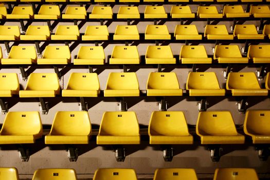 many yellow chairs with harsh light from side