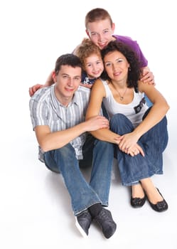 Beautiful middle aged couple carrying cute kids and smiling over white background