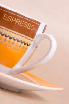 orange espresso cup on ochre background