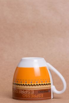 orange espresso cup on ochre background