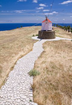 Old small windmill on the Portuguese island of Porto Santo, stony footpath