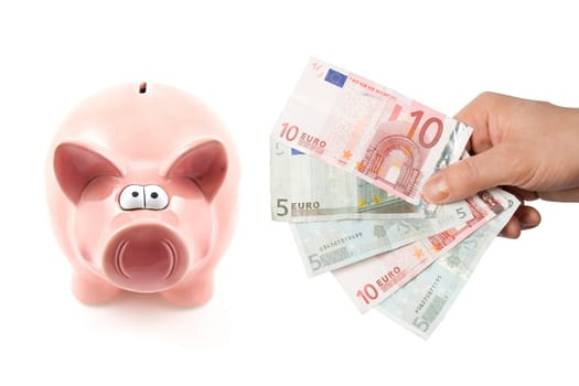 Piggy bank and hand with banknotes isolated on white background